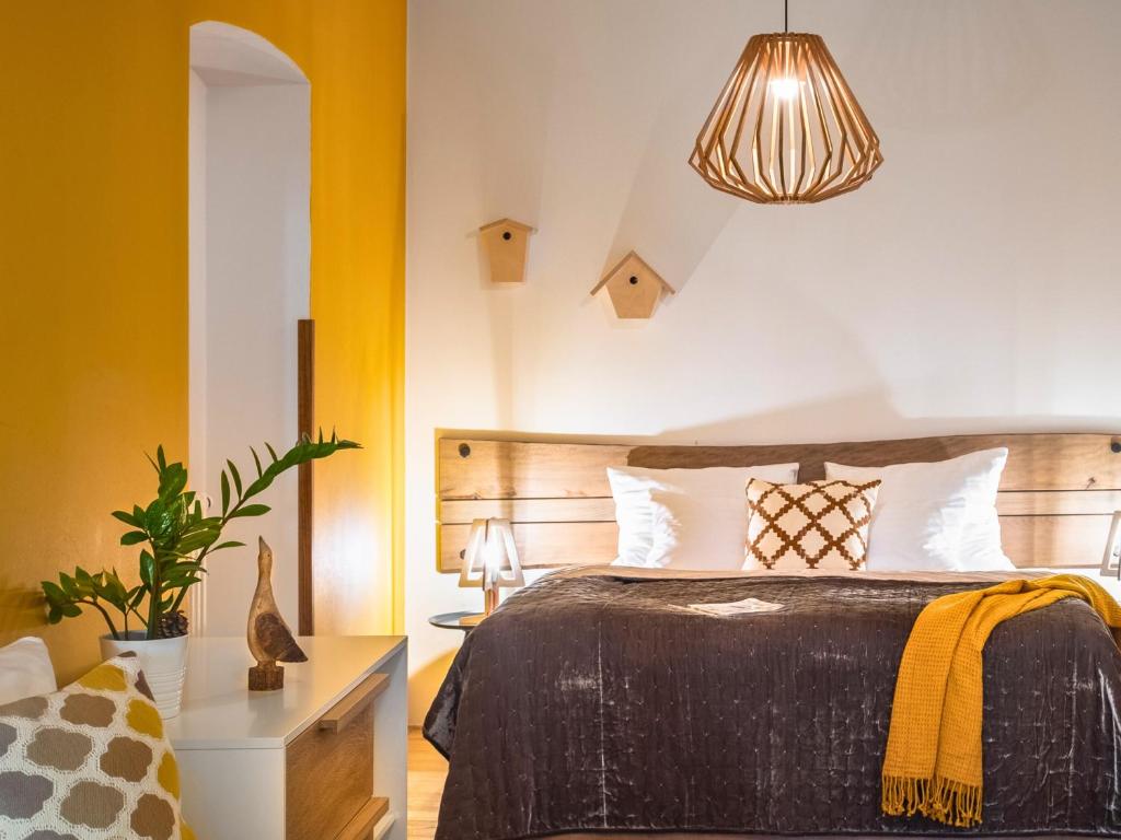 a bedroom with a bed and a yellow wall at 4 Trees Apartments by Adrez Living in Prague