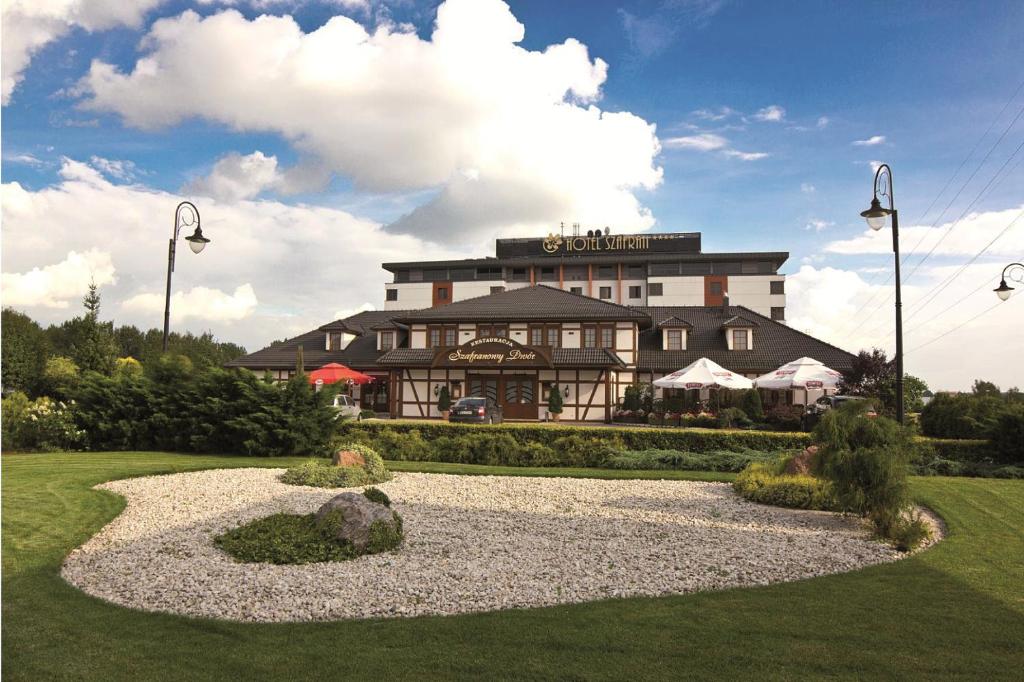 a large building with a garden in front of it at Hotel Szafran in Czeladź