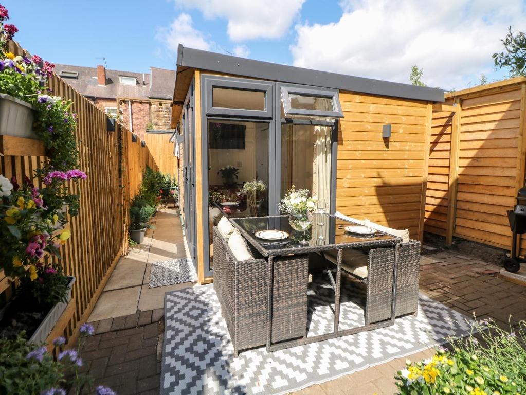 un pequeño jardín con una mesa en un cobertizo en Garden Suite en Dronfield