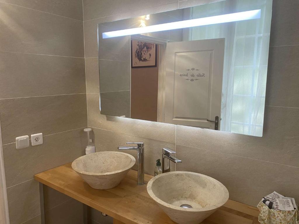 a bathroom with two sinks and a large mirror at B&amp;B Au bois dormant chambres d hotes in Tillé