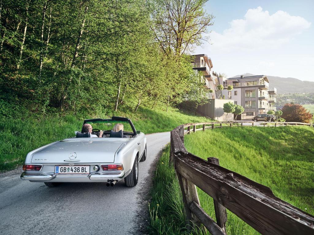 a car driving down a road with two people in it at Chalets Coburg in Schladming