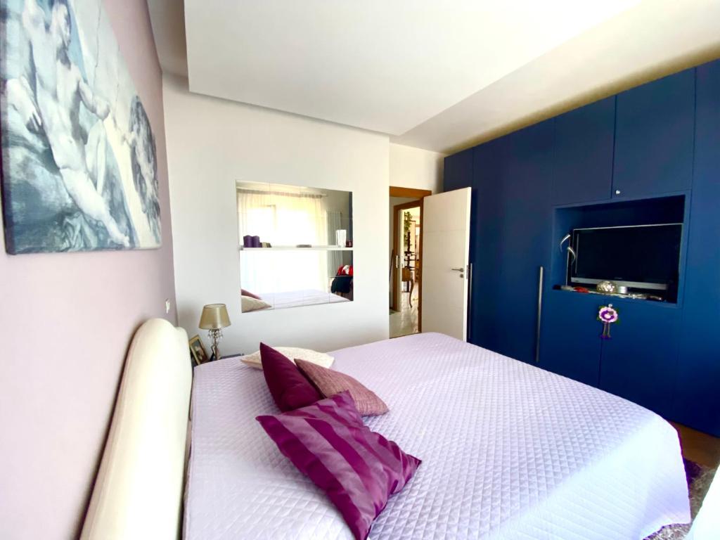 een slaapkamer met een wit bed met paarse kussens bij Seeview rooftop house between Sorrento and Amalfi in Massa Lubrense