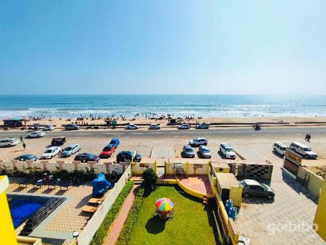 a beach with a lot of parked cars and the ocean at Hotel Golden Dust ! Puri - ViDi Group of Hotels in Puri