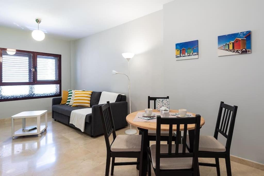 a living room with a table and a couch at Modern Apartment Canteras Beach in Las Palmas de Gran Canaria