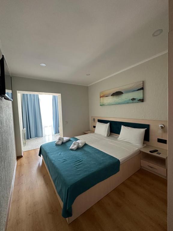 1 dormitorio con 1 cama grande con manta azul en Apart-Hotel Poseidon, en Odessa