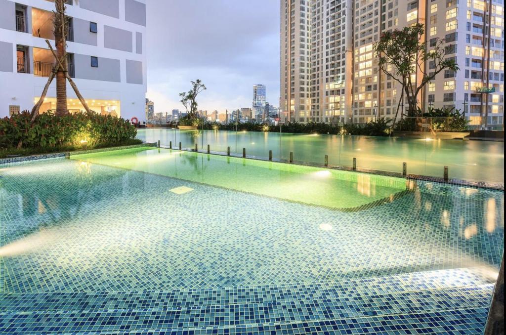 a swimming pool in a city with tall buildings at Genius Apartment River Gate Free Pool in Ho Chi Minh City