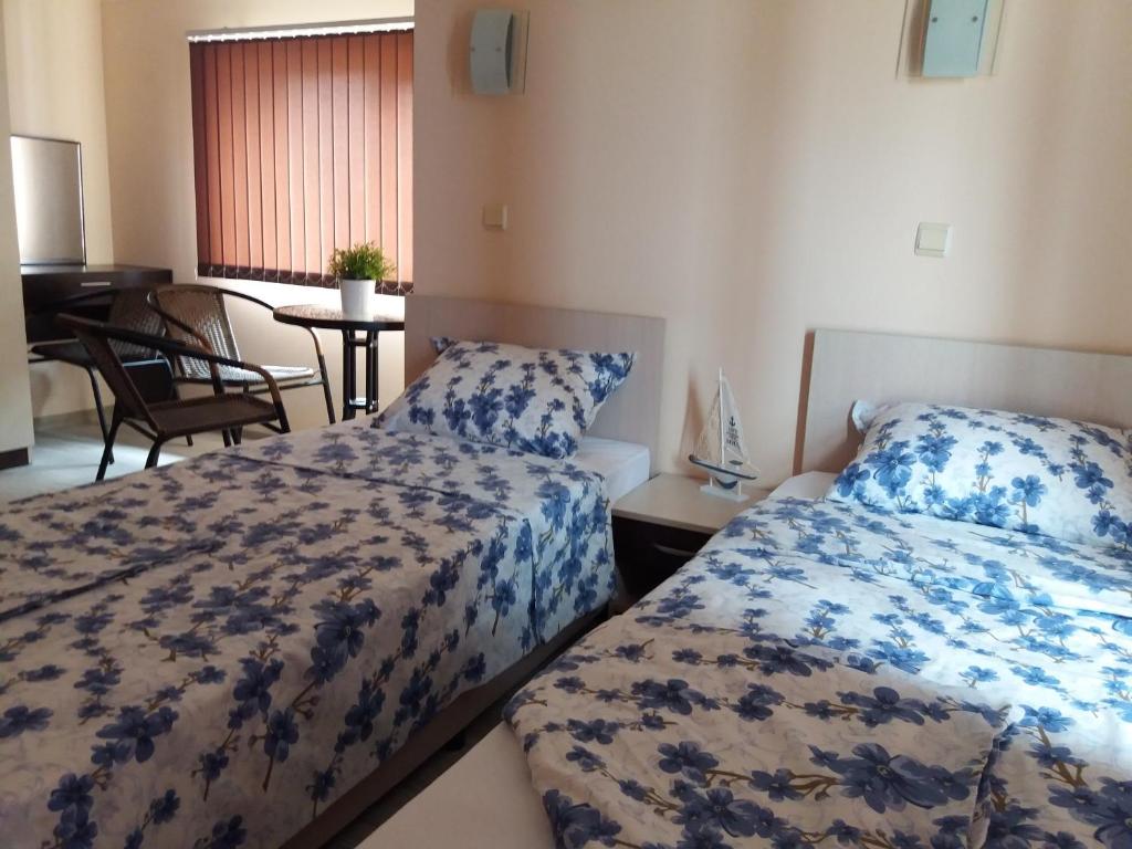 a bedroom with two beds and a table with a piano at Апартамент в комплекс Зора 9A in Sozopol