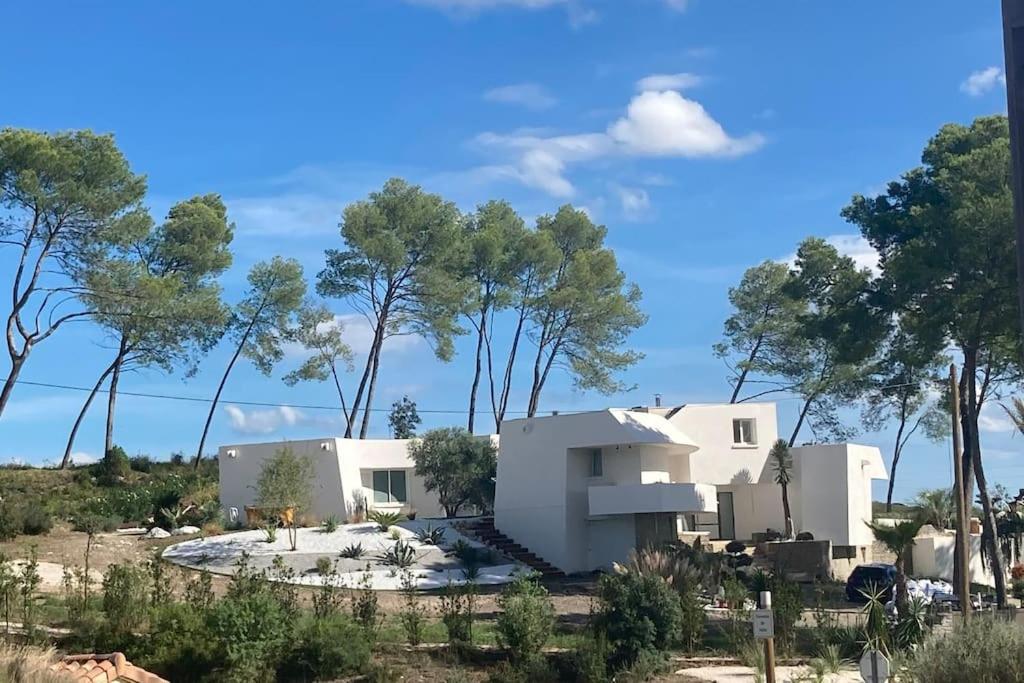 a house in the desert with trees in the background at Villa design vue panoramique in Grabels