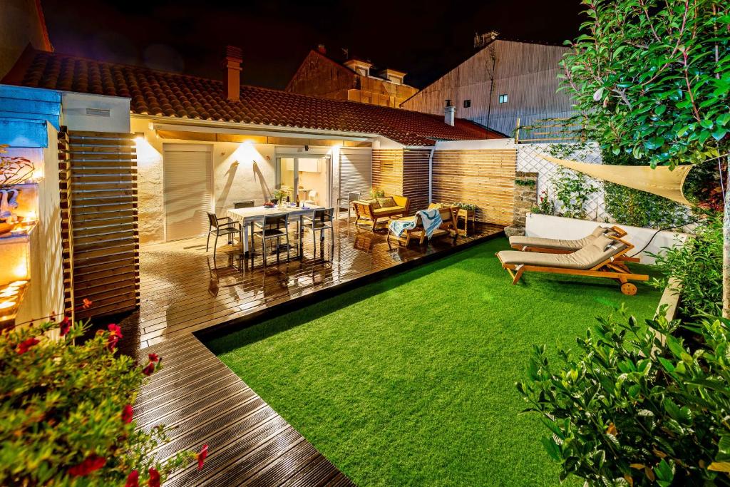 a backyard with a green lawn and a house at casaplayasanxenxo in Sanxenxo