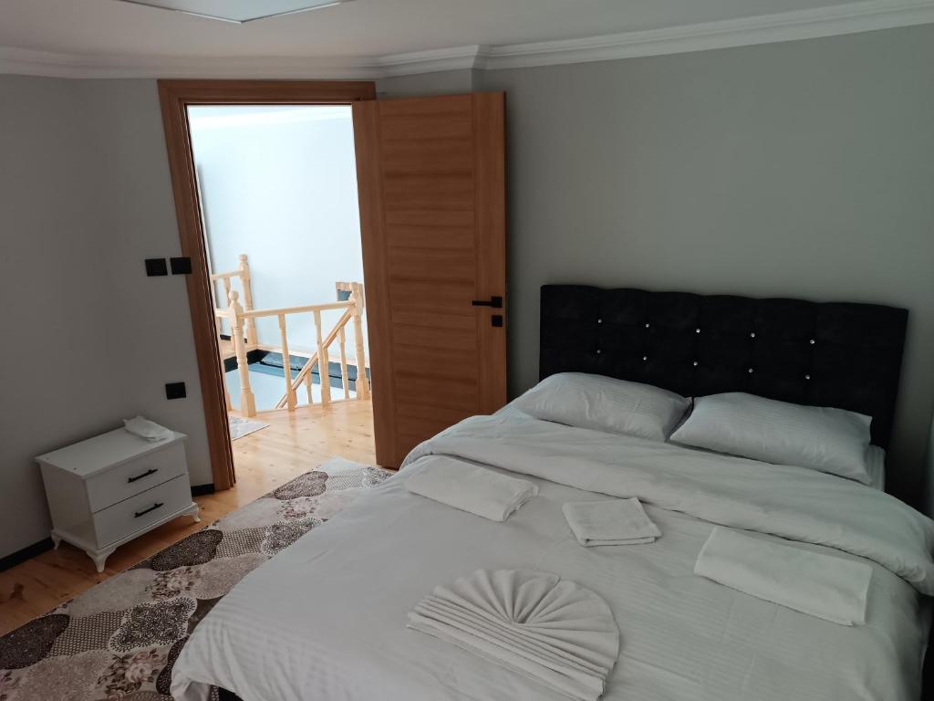 sypialnia z dużym białym łóżkiem z czarnym zagłówkiem w obiekcie Uzungöl-Daire-Apart-Kiralık w mieście Çaykara