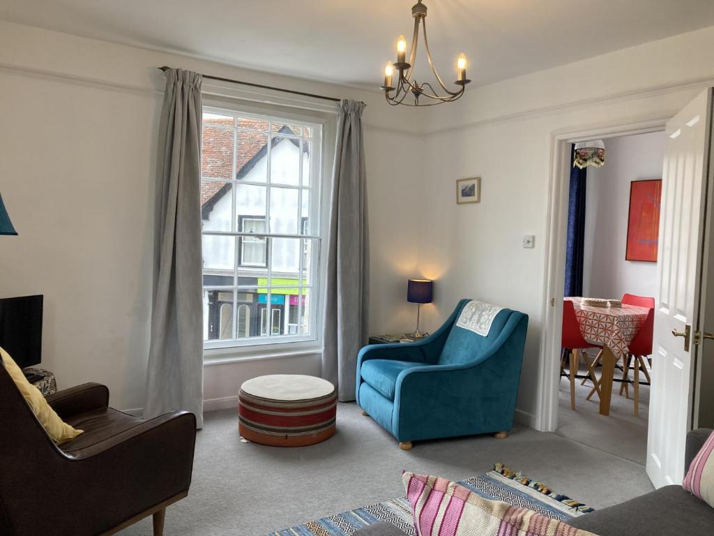 a living room with a blue chair and a window at House On The Hill in Framlingham