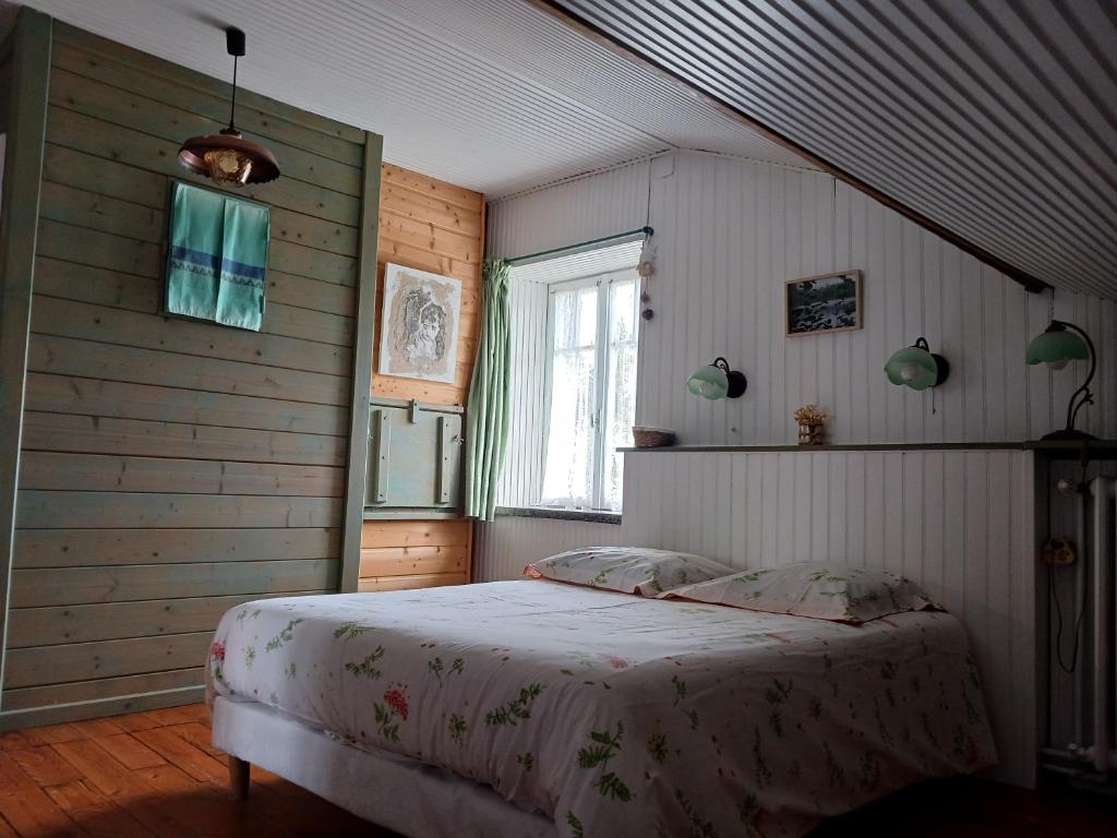 um quarto com uma cama no canto de um quarto em Ferme du Haut Barba em Liézey