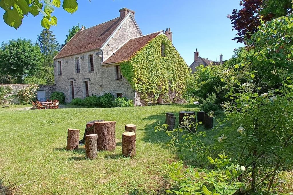 ein altes Haus mit Stümpfen im Gras davor in der Unterkunft Domaine de l'Ormerie Provins in Provins