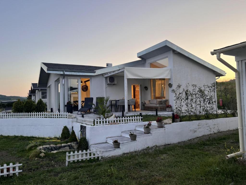 uma casa branca com uma cerca à frente. em villas 21,22 Albena sea view em Rogachevo