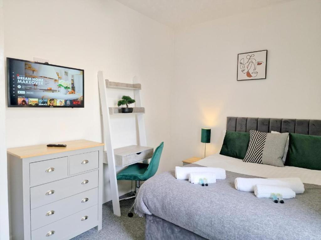 Schlafzimmer mit einem Bett, einer Kommode und einem Schreibtisch in der Unterkunft St Johns House in Burnley