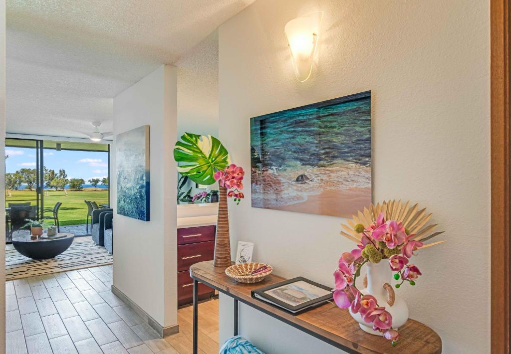 sala de estar con mesa y jarrón con flores en Waikoloa Villas A107, en Waikoloa