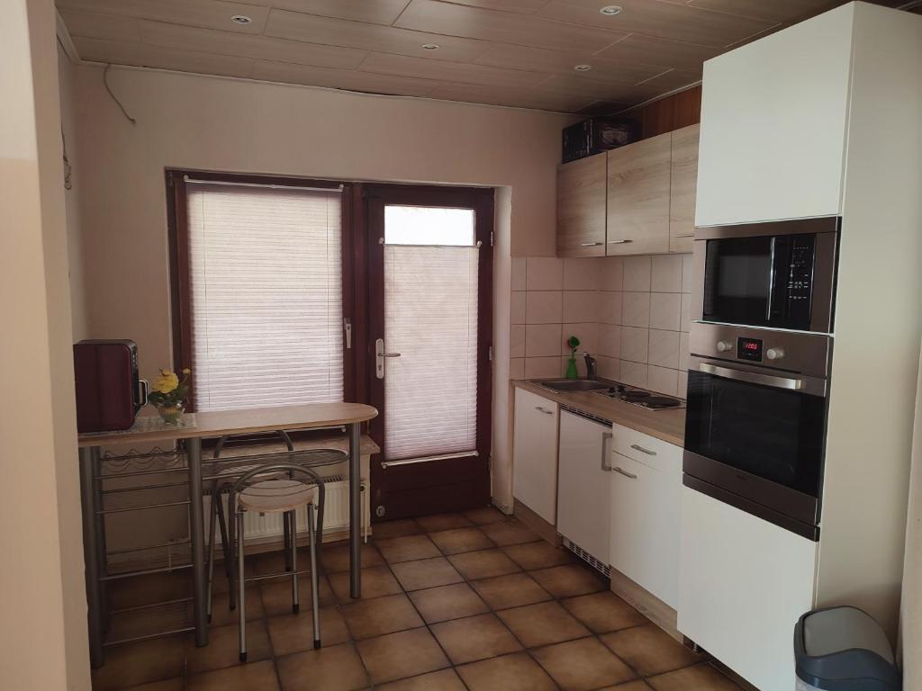 uma pequena cozinha com mesa e cadeiras em Appartement am Waldesrand em Gifhorn