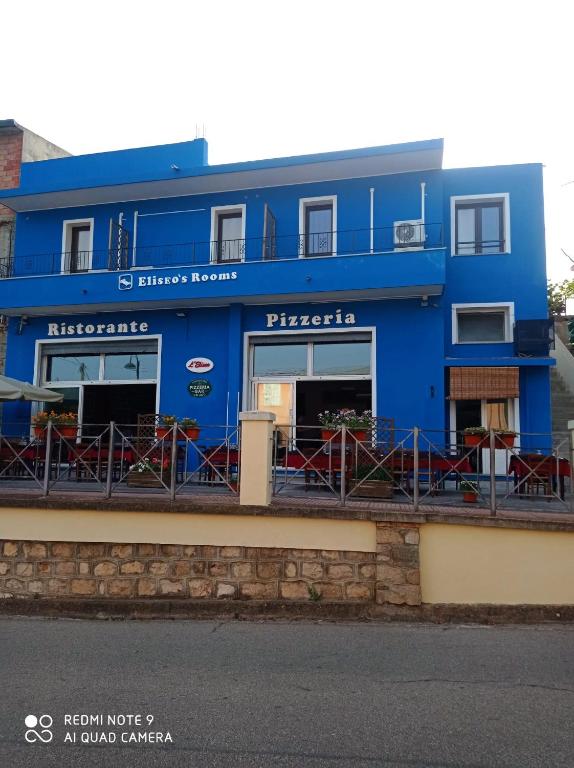 a blue building on the side of a street at Eliseo&#39;s rooms in Triei