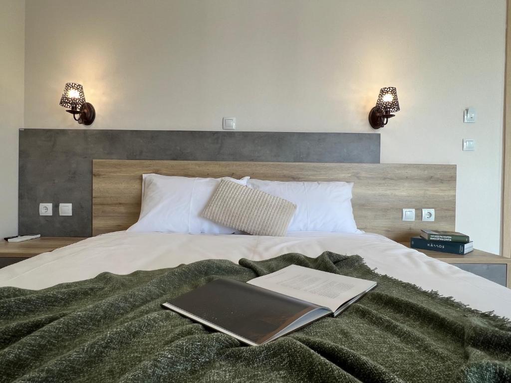 un letto con un libro e un computer portatile di Zilean apartments by Airstay a Spata