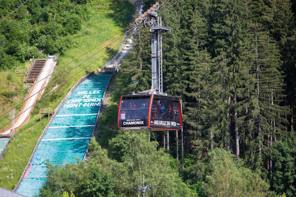 a gondola ride down a hill next to a river at Duplex stylé face à l'Aiguille du Midi in Chamonix-Mont-Blanc