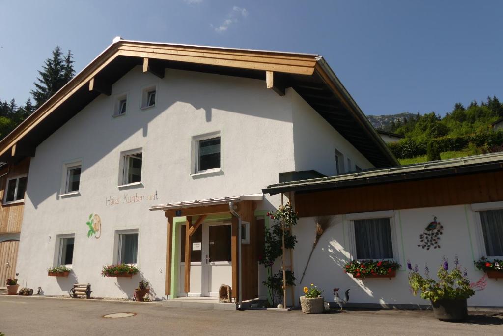 ein großes weißes Gebäude mit Blumen davor in der Unterkunft Ferienwohnungen Haus Kunterbunt in Berchtesgaden