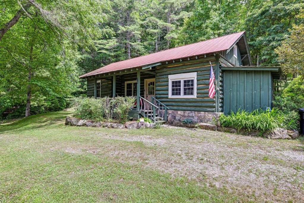 a log cabin with an american flag in front of it at Historic Sapphire Cabin with Porch, Updated Interior in Sapphire