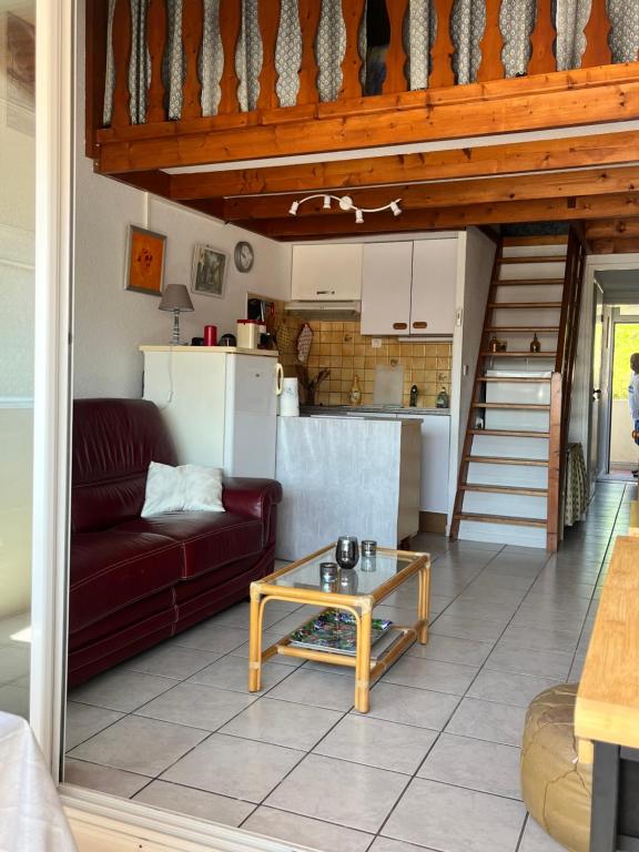 un salon avec un canapé rouge et une table dans l'établissement Appartement 6 couchages La Londe-les-Maures 8, à La Londe-les-Maures