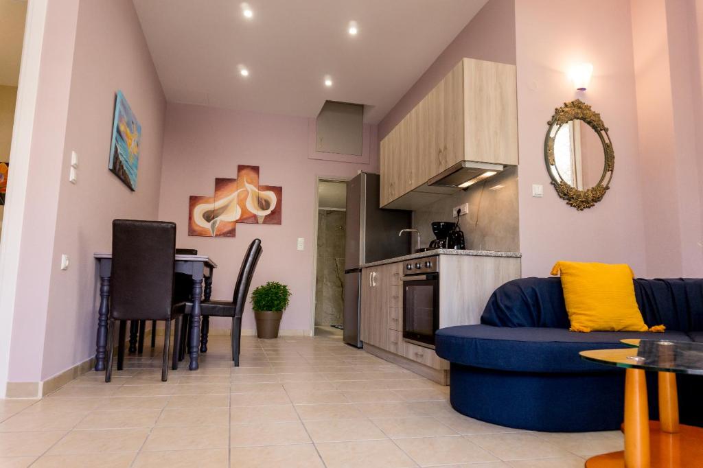 a living room with a blue couch and a kitchen at Aktia Apartments, Preveza in Preveza
