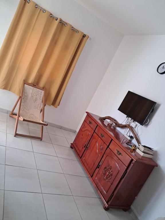 a room with a dresser and a lamp and a chair at Maison tartanaise in La Trinité