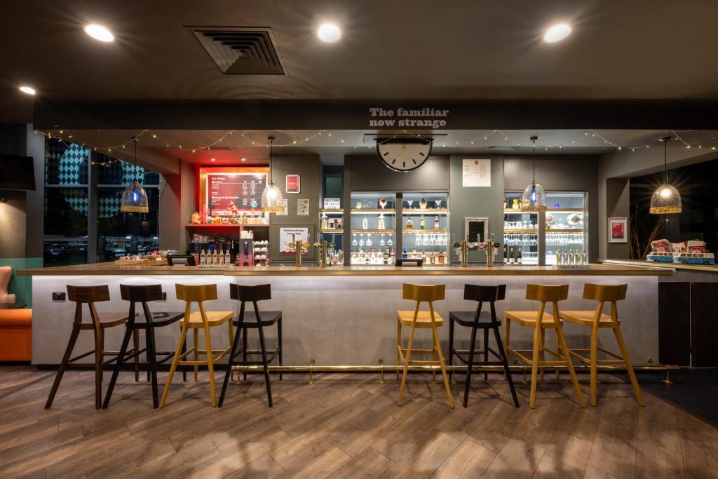 a bar in a restaurant with stools at Leonardo Hotel Brighton in Brighton & Hove