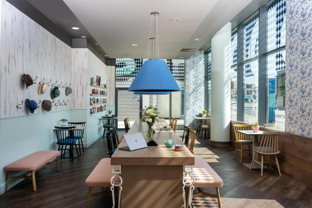 a dining room with a table and chairs and windows at Leonardo Hotel Brighton in Brighton & Hove