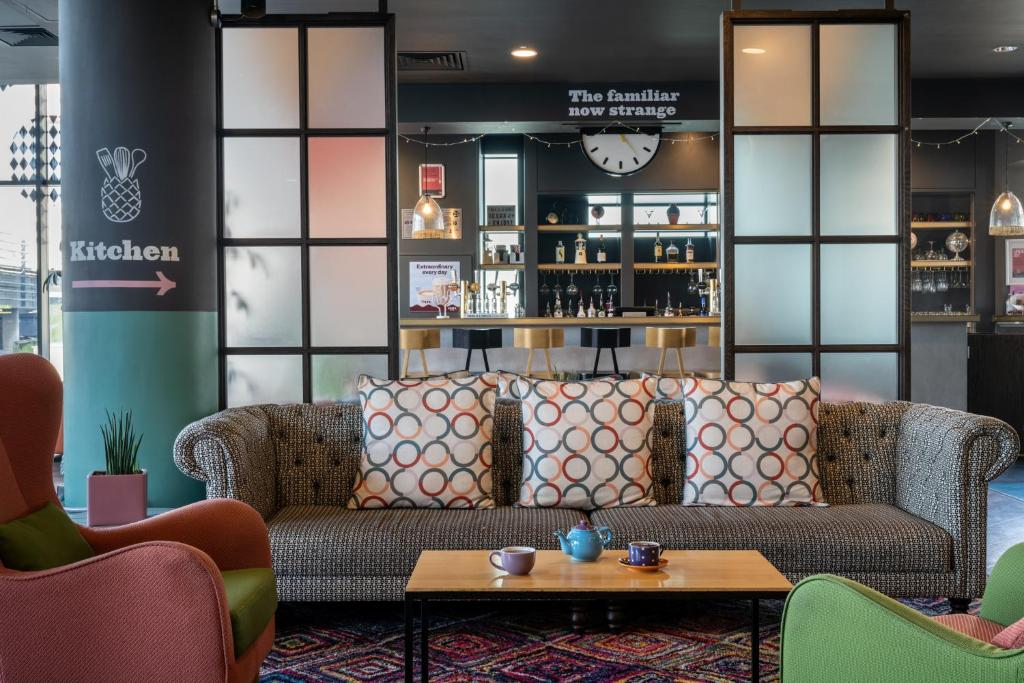 a living room with a couch and a table at Leonardo Hotel Brighton in Brighton & Hove