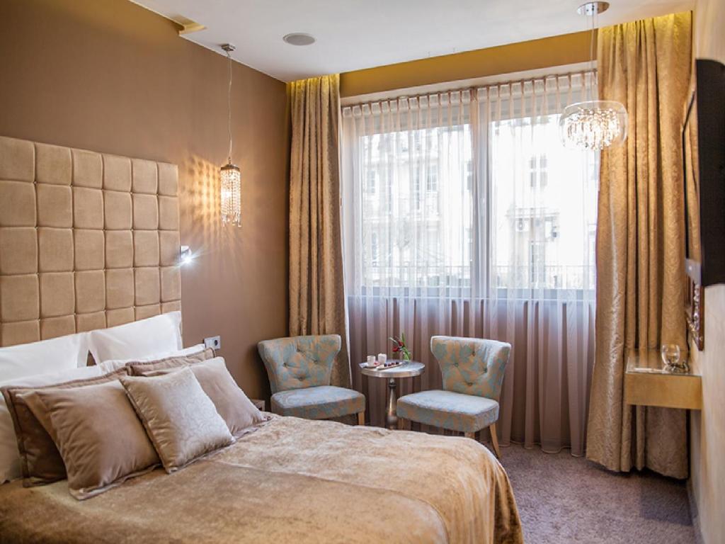 sypialnia z łóżkiem, stołem i oknem w obiekcie Soleil Boutique H w mieście Sopot