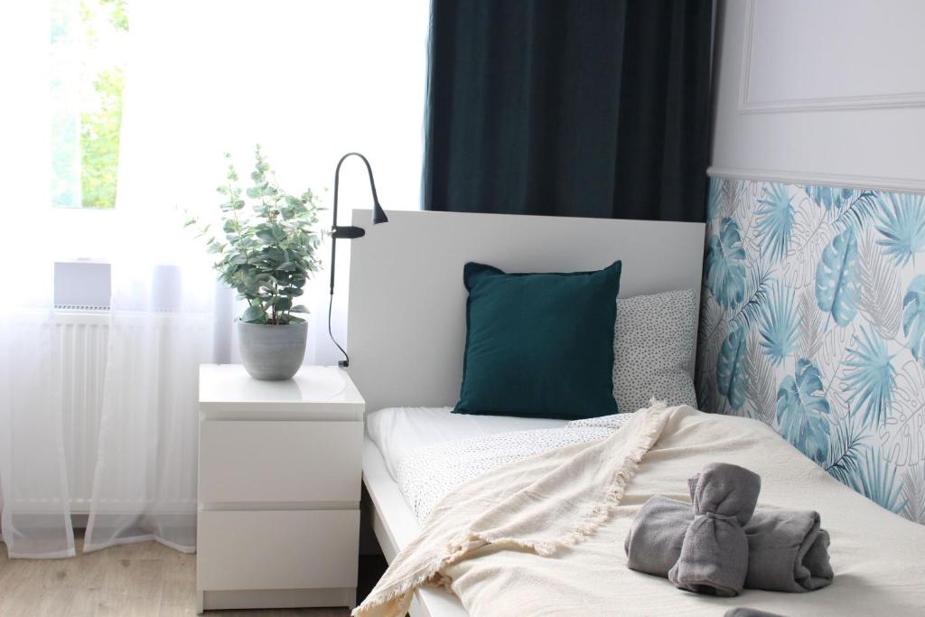 a bedroom with a bed with a green pillow at Elegancki apartament w centrum Warszawy in Warsaw
