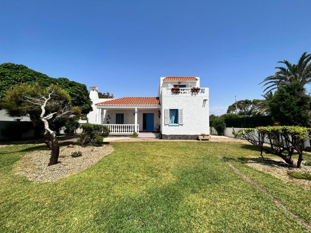 a white house with a yard with trees at Casa Manuela frente al Mar in Roquetas de Mar