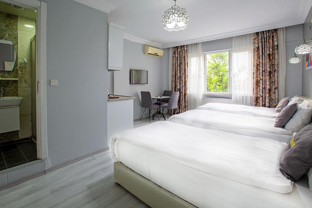 een hotelkamer met 2 bedden en een tafel bij Unique Suite Hotel in Istanbul