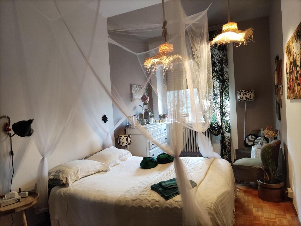 a bedroom with a white bed with a canopy at RaMaya, casa d'artista in Biella