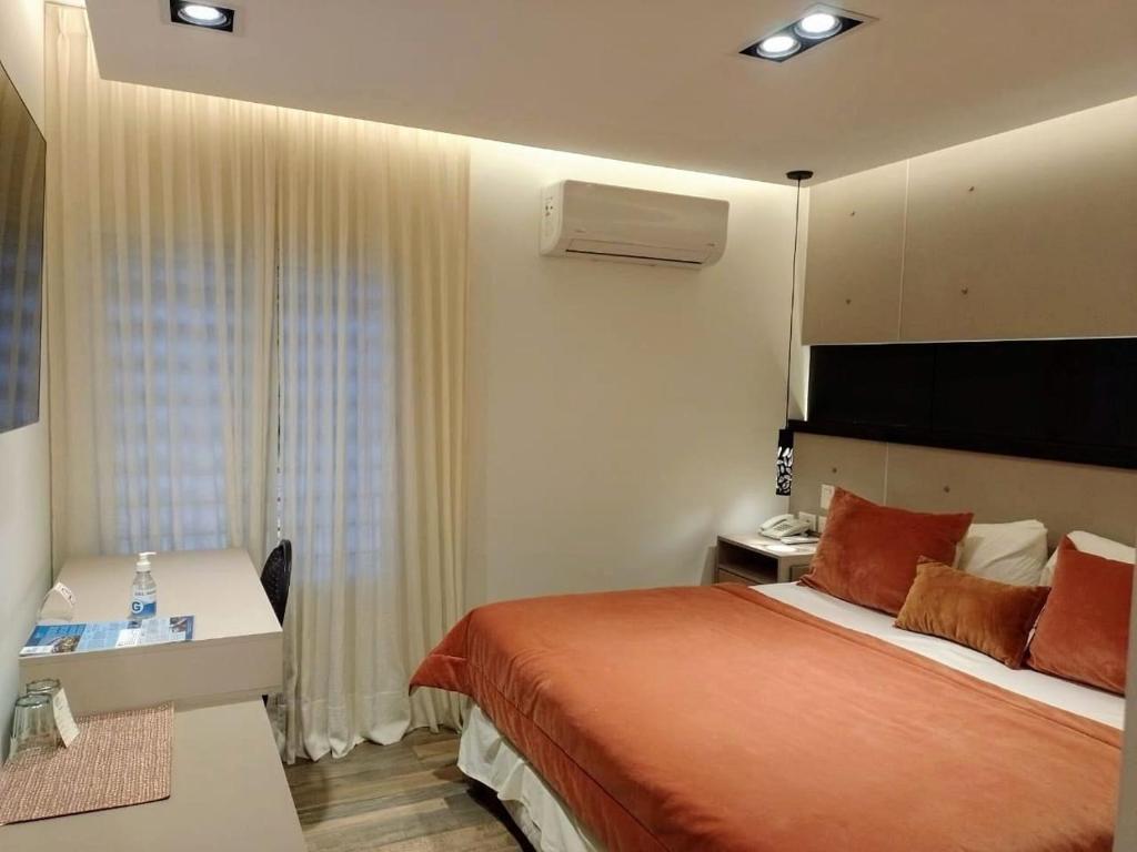 Habitación de hotel con cama y escritorio en Global Hotel en Centenario