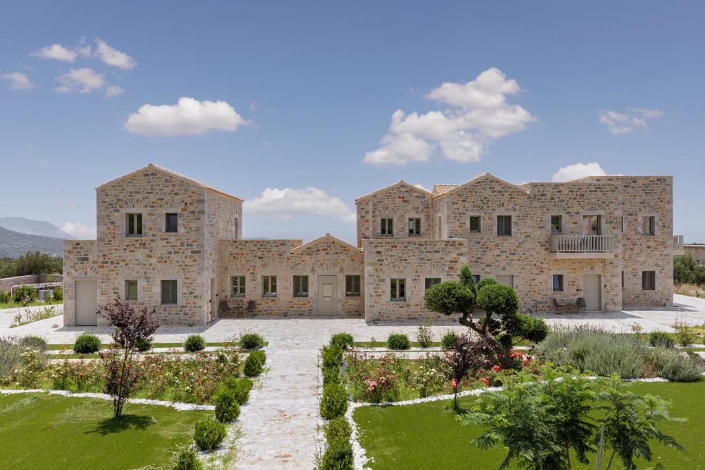 an exterior view of a large stone building with a garden at Margazi Areopolis Luxury Rooms in Areopolis