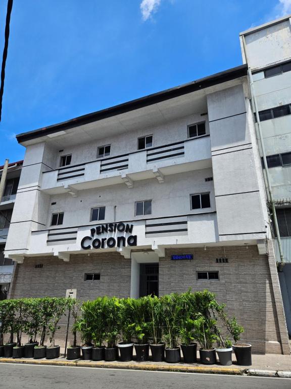 Ein weißes Gebäude mit einem Schild drauf. in der Unterkunft Hotel Pension Corona in Panama-Stadt