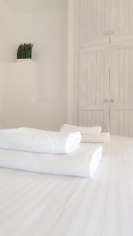 two white towels are sitting on top of a bed at Spilia Apartments in Stavros