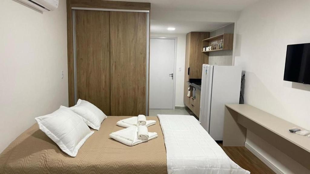 a small room with a bed with towels on it at Apartamento Studio Centro Poços de Caldas in Poços de Caldas
