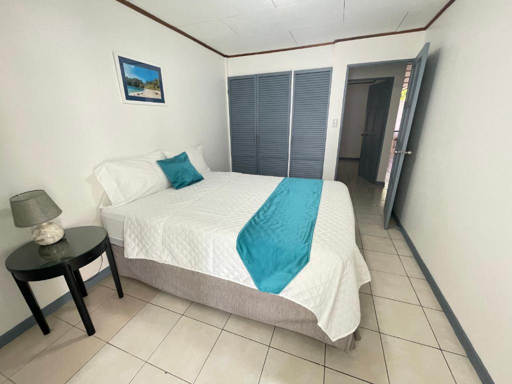 Dormitorio pequeño con cama y mesa en 3 Min from SJO airport Kaeli en Alajuela City