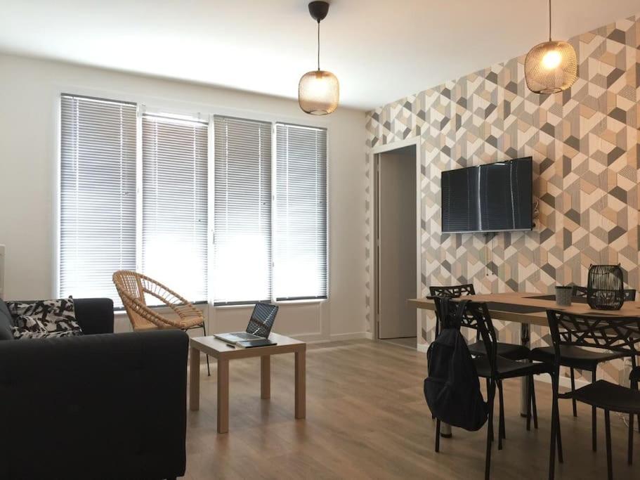 a living room with a table with a laptop on it at Appt 4 chambres avec balcon, Spinelle in Ifs
