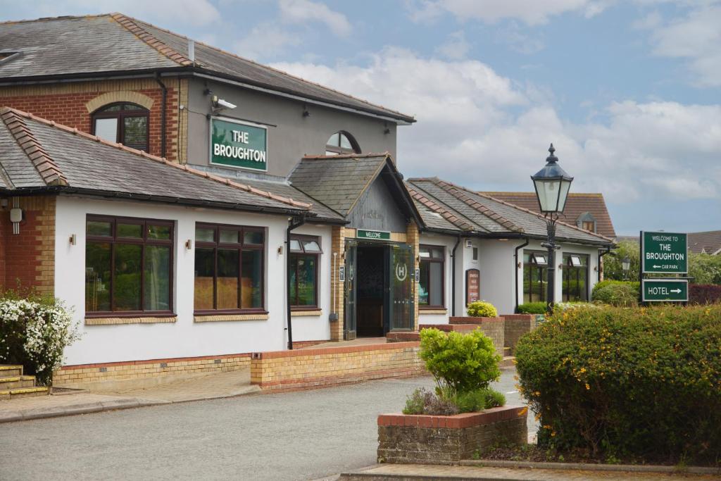 a building with a sign that reads the station at The Broughton Hotel by Greene King Inns in Milton Keynes