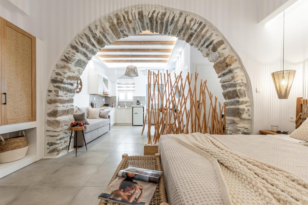 een slaapkamer met een bed en een stenen boog bij Philisios Home 1 in Naxos Chora