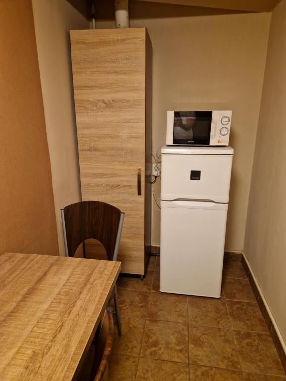 una pequeña cocina con microondas encima de una nevera en Splendor apartman, en Debrecen