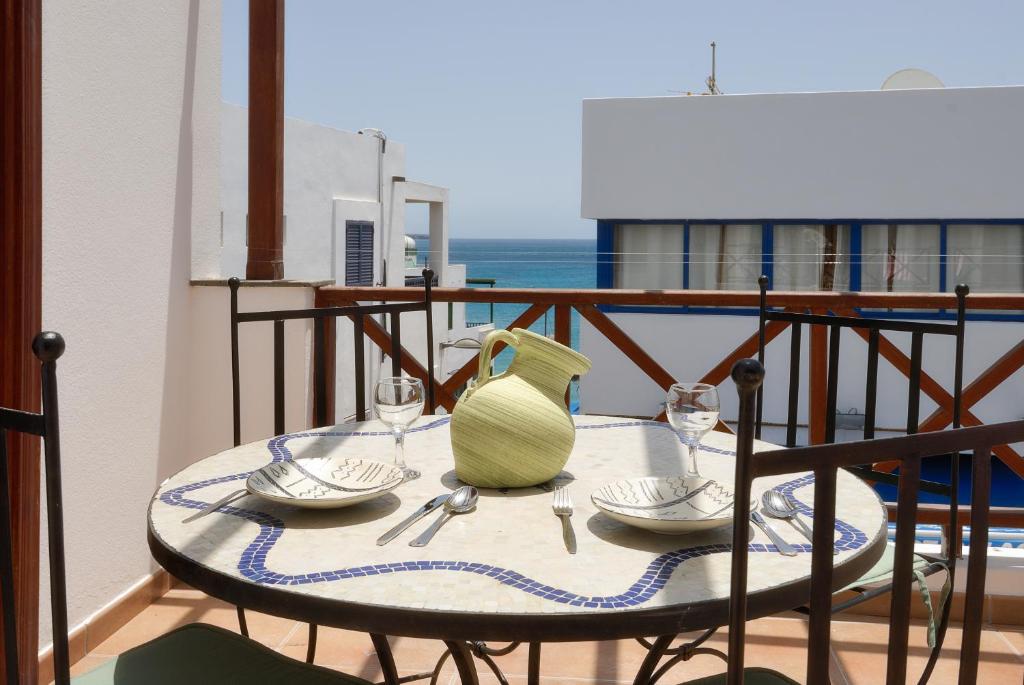 una mesa con un jarrón en la parte superior de un balcón en Apartment Limonade Deluxe Main Center Playa Blanca By PVL en Playa Blanca