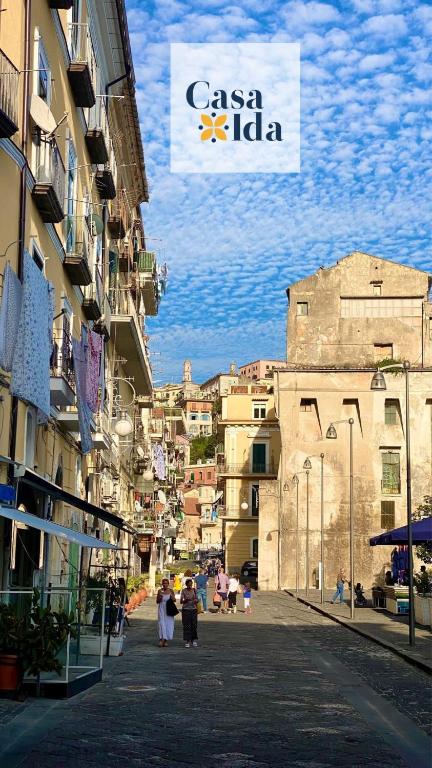 un grupo de personas caminando por una calle con edificios en Amalfi Coast Casa Ida, en Vietri