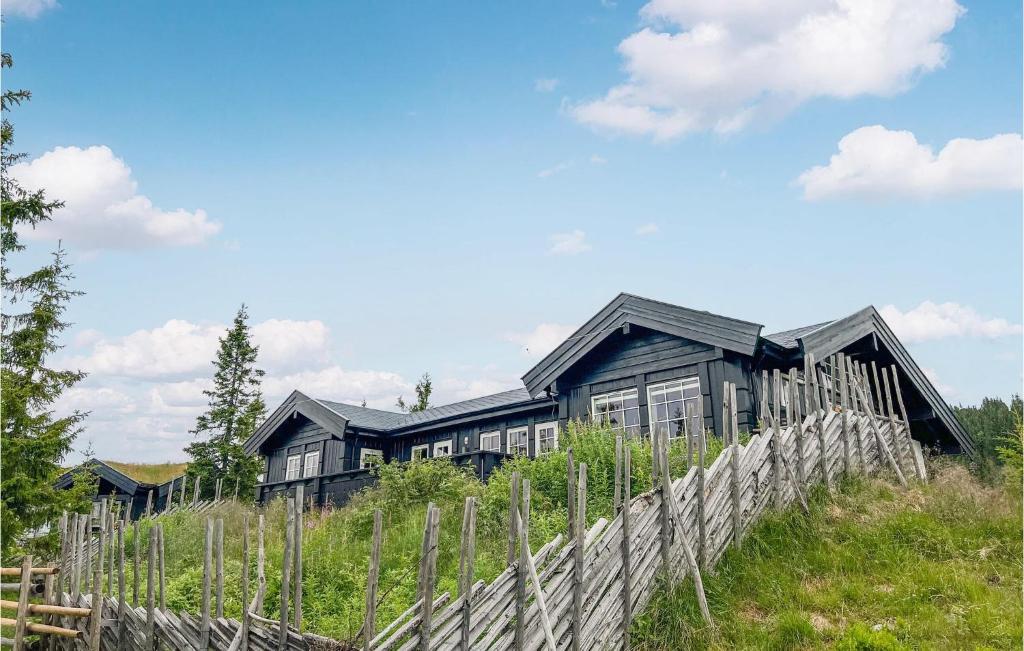 una casa en la cima de una colina con una valla en Pet Friendly Home In Sjusjen With Sauna, en Sjusjøen